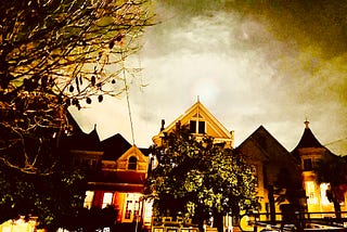 Four San Francisco Victorians act as sentinels by the light of a full moon surrounded by clouds full of foreboding.