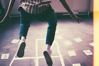 A researcher playing hopscotch on a paper prototype