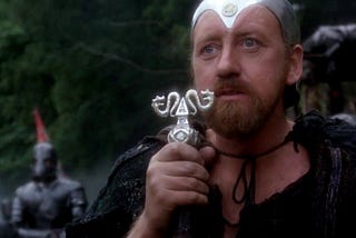 Merlin (Nicol Williamson) holding his wizard’s staff in Excalibur.