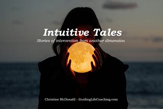 Dark silhouette of woman holding a moon lamp with two hands illuminating her face — a faded ocean in the background. This is the cover photo for the Intuitive Tales series by Christine McDonald