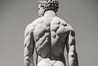 An ancient Greek statue of a muscular man with very good and lean back muscles