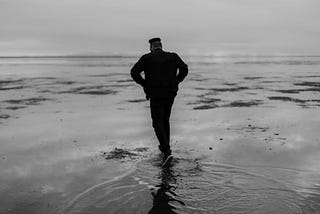 A person walking across a wet path, looking uncomfortable. Your comfort zone might be a lie.