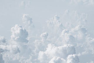 A view from above white, towering clouds brightly illuminated by the sun.