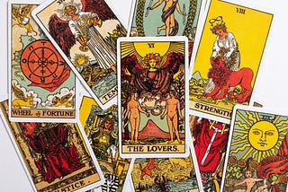 a jumbled pile of tarot cards in traditional art style with The Lovers card at the centre.