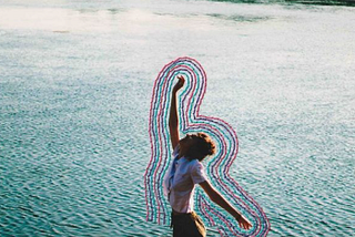 fotografia de uma pessoa pulando com um rio ao fundo. todo o contorno da pessoa está bordado com linhas coloridas