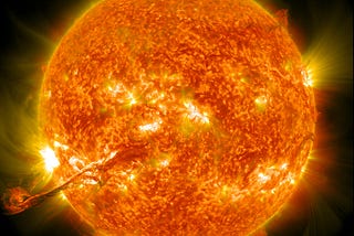 The NASA title for this photo is “A corona mass ejection erupts from our sun on August 31, 2012.” This is a color photograph of our sun showing incredible detail and bright orange and yellow and dark red colors.