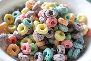 Close-up photo of brightly colored cereal loops piled in a white bowl.