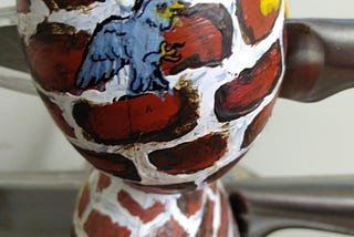 close-up of painted knife holder shaped like a person.