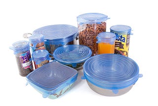 several bowls, cans, and other food containers covered with stretchy silicone lids