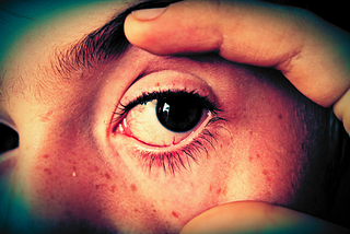 A person holding their eye open.
