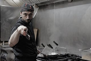 Italian chef cooking and looking serious