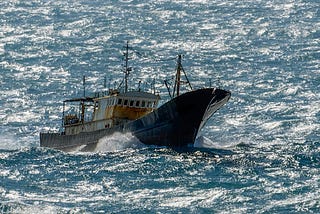 Small chinese trawler pounds through rough seas as it crosses the South China sea.