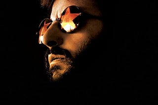 Picture of Ringo Starr wearing glasses in dark lighting