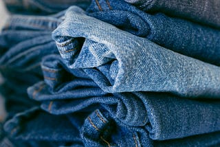 A pile of jeans in different shades of blue