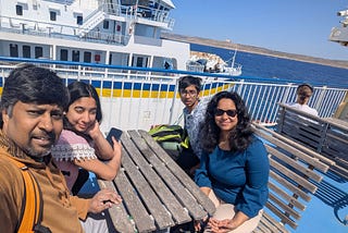A picture of the author and her family at a table near the water.