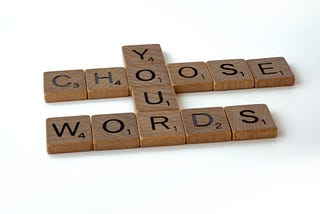 Scrabble pieces spelling out, "Choose your words."