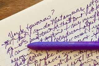 writing in purple ink with a purple pen across the page