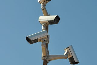 Four surveillance cameras pointed at slightly different angles all on one post