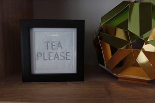 A tea please sign in a frame, unlit