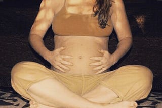 A pregnant woman doing prenatal yoga, concerned about weight gain in pregnancy.