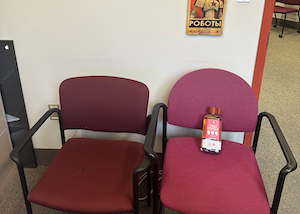 Two chairs in my office. One has a bottle of “Tres Comas” tequilla on it.