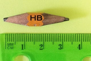 A 3.5 cm pencil sharpened at both ends lying next to a ruler
