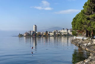 Building sit along the shoreline of a lake.