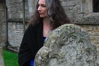 author standing by an old headstone
