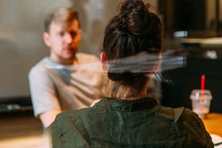 Two people in a meeting room facing each other.