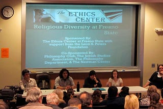 Four panelists at an Ethics Center event title “Religious Diversity at Fresno State. Slide reads, “sponsored by the Ethics Center at Fresno State; co-sponsored by the Philosophy Club, Jewish Studies Association, the Philosophy Department, and the Newman Center.”