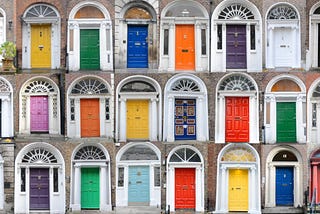 photo of 24 front doors of various colors, all with arched transoms
