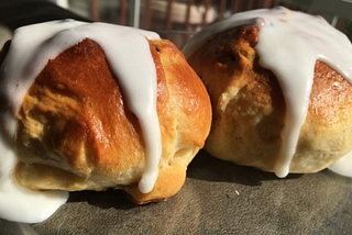 two hot cross buns with icing on a plate