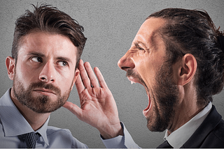 man shouting at auditory impaired man without being heard