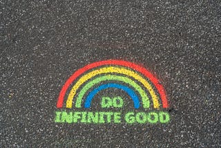 Design painted on concrete of a rainbow over the words Do Infinite Good.