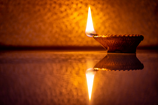 Oil lamp burning on table in dark room