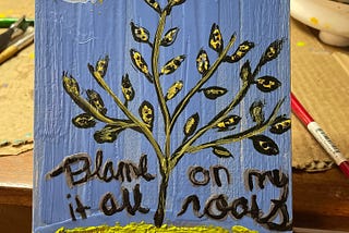 An encaustic painting of a diseased plant over a blue background, with the description “Blame it all on my roots.”