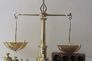 An old-fashioned two-pan balance scale, from Wikimedia by Jean Poussan