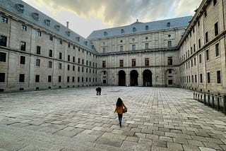 Tres personas en el patio central de El Escorial