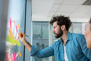 Male writing on sticky notes