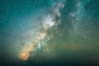 Field of stars in the Milky Way cascading down to the shore of the sea, showing so much light