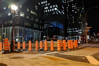 Orange cones lined up to cover two lanes of the road. Near CHUM and Old Montreal September 2021.