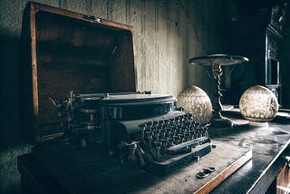An antique typewriter sitting on a wooden desk
