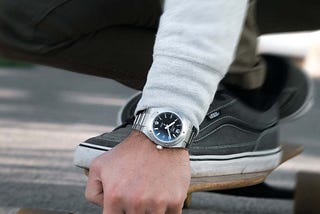 Man wearing a IWC Ingeneur wrist watch while riding is longboard. Motion blur