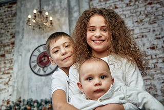 Three Children Wearing White Indoors Portrait