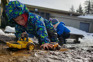 A child plays with toys in the mud at Play Frontier in Skamania County.