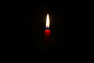 A single candle burning in the dark.