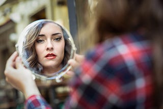 A woman looks at herself in the mirror