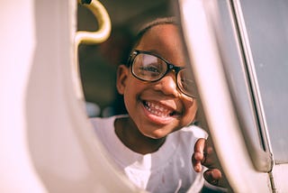 A child in glasses smiling at the camera