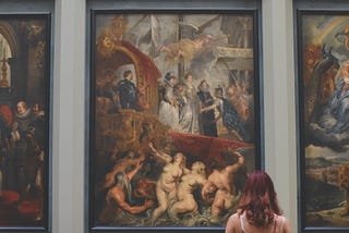 A women looking at classic paintings in a museum