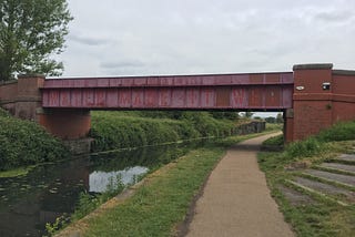 Water Made it Wet. A text based work by Lawrence Weiner — written along a metal bridge over the old canal.